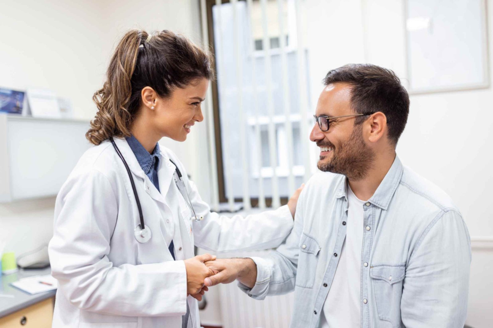 jpeg-optimizer_young-woman-doctor-gp-white-medical-uniform-consult-male-patient-private-hospital-female-therapist-speak-talk-with-man-client-consultation-clinic